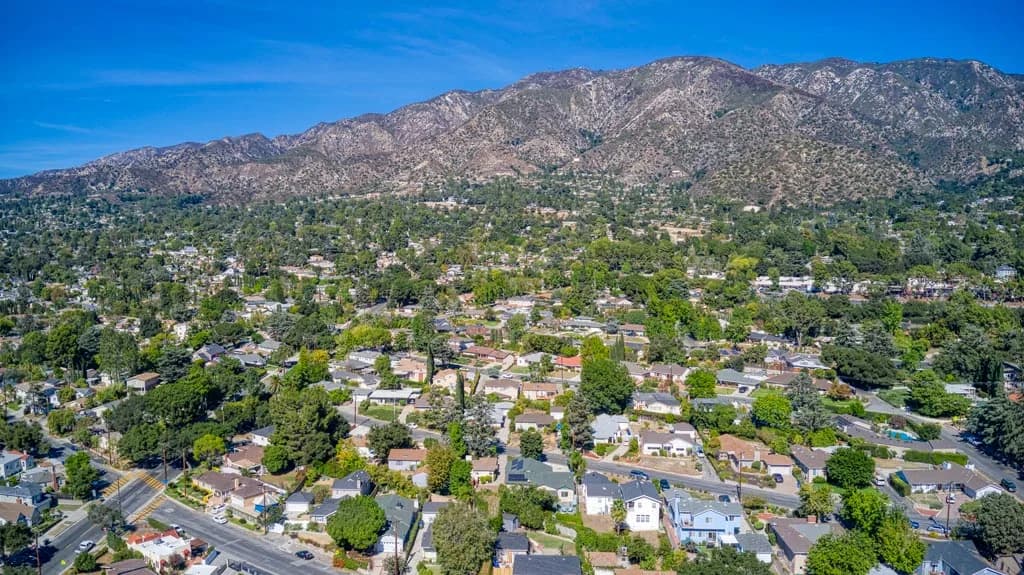 Aerial view of La Crescenta homes and tree-lined streets below the San Gabriel Mountains